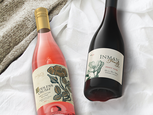 Bottle of Inman Family Endless Crush Rose and RRV Pinot noir lying on a bed
