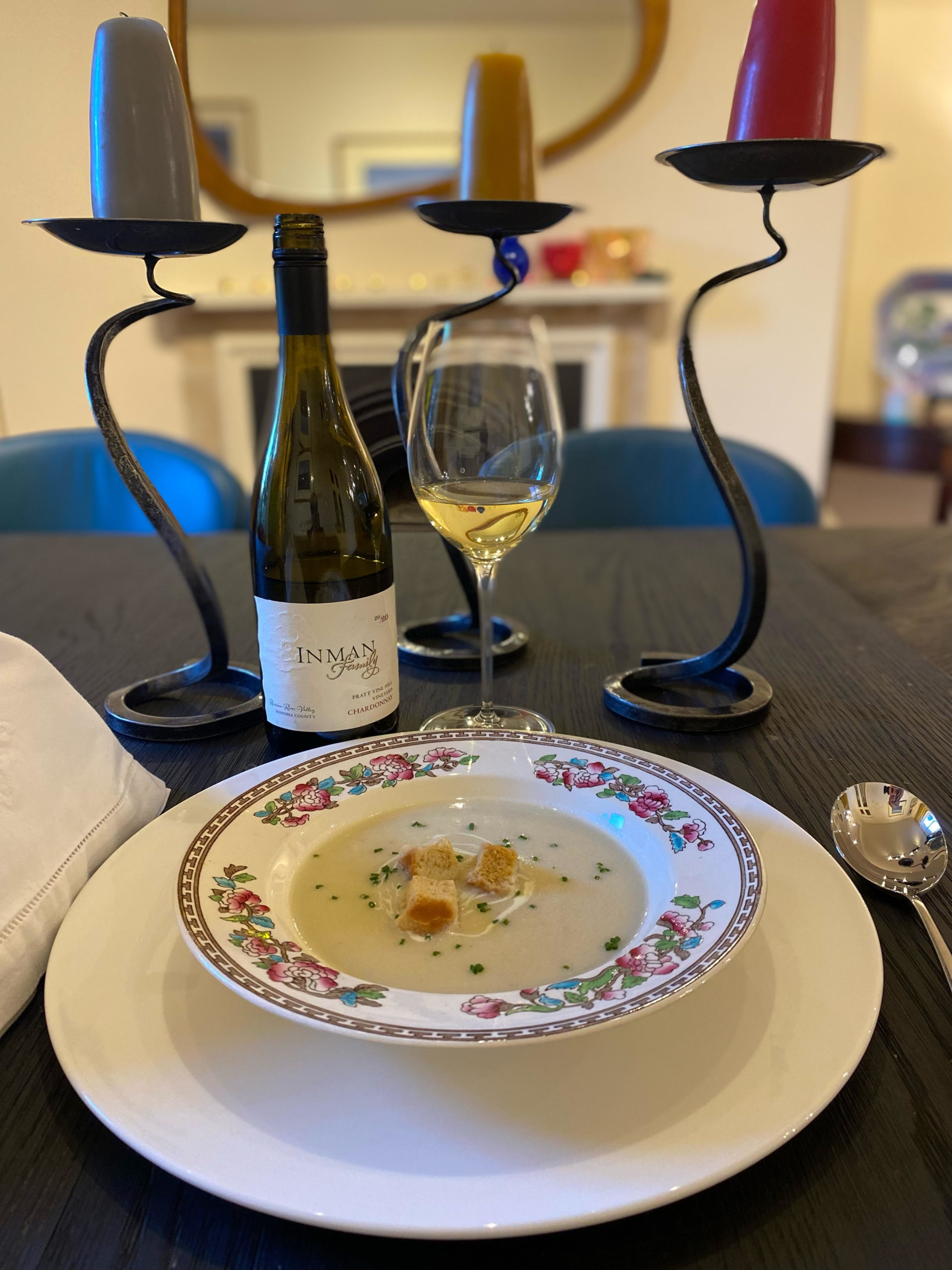 Glass of Inman Family chardonnay paired with a creamy celeriac soup on a dining table